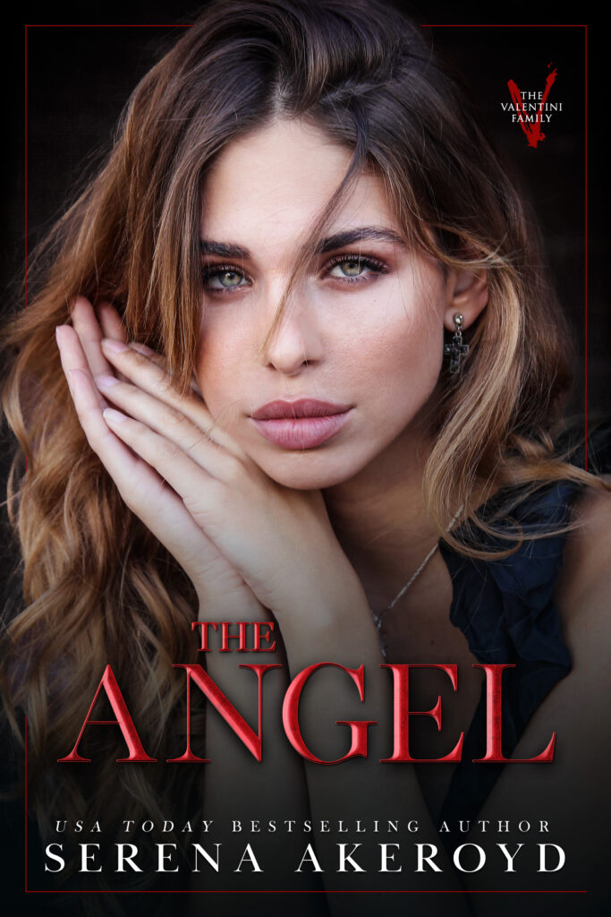 A beautiful woman with brown to blonde ombre hair with her hands pressed together against the side of her face. She is wearing a black ruffled tank top style blouse. Text reads: The Angel, USA Today Bestselling Author Serena Akeroyd